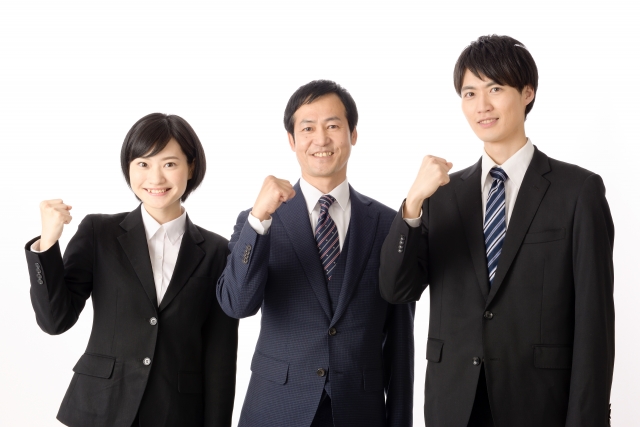 20代、30代、40代の男女が並んでいるガッツポーズ