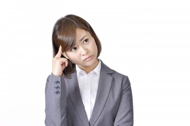 転職に不安を感じて頭に手を乗せているビジネスウーマン