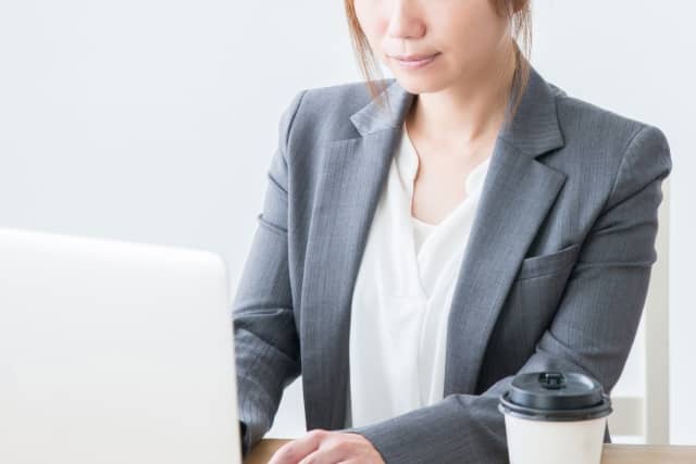 スーツを着た女性が転職のきっかけを考えている