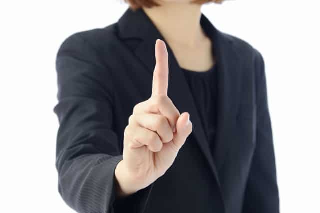 転職エージェントは使えないと思っている女性が人差し指を指している