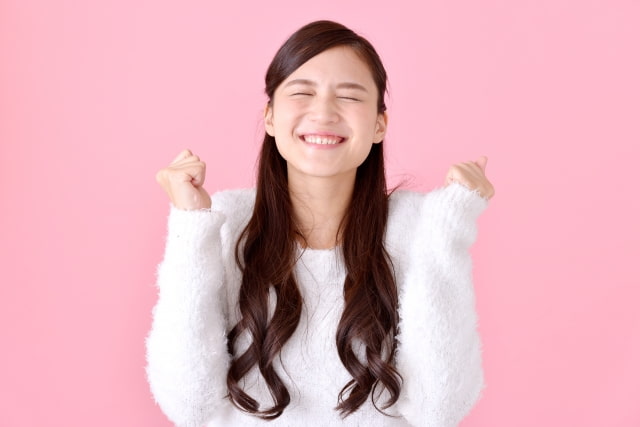 転職して年収が上がって嬉しそうに両手を上げてている女性