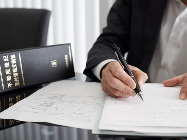 人と関わらない仕事をノートにまとめているスーツを着た男性