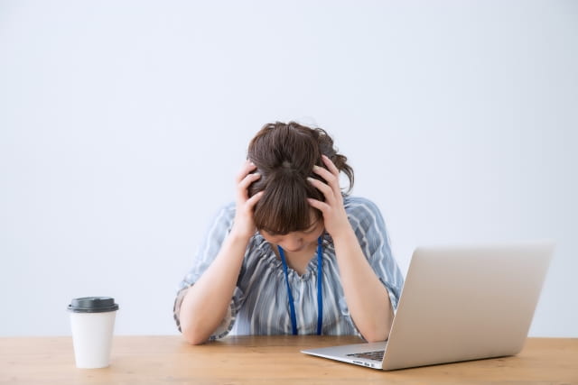 仕事を辞めたいのに言えない女性が頭を抱えている