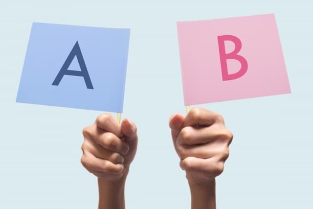 ハタラクティブの評判と他社を比較するAとBの旗を持つ両手