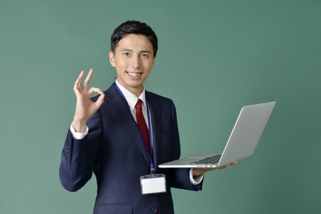転職でキャリアアップできる!と手でOKサインをしているスーツを着たビジネスマン